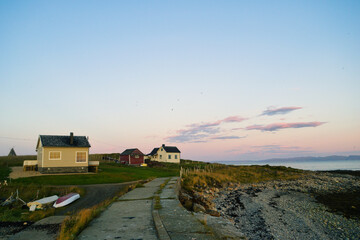 Beautiful shot of a fjord with coastal houses in Ekkeroy, Varanger, Norway at sunset