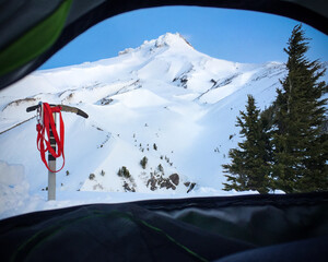 View out of a climber's tent looking at the summit of Mount Hood, Oregon, with an ice axe stuck in the snow
