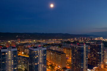Obraz premium Moon over the city, high-rise buildings, night, mountains