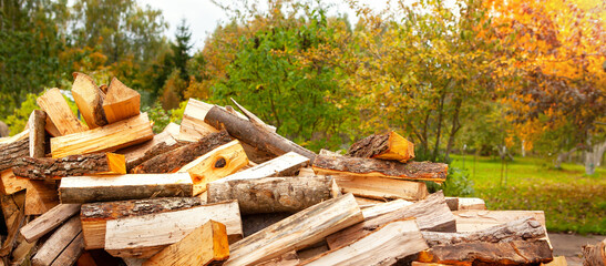 A pile of split firewood for heating a house, in an open space.