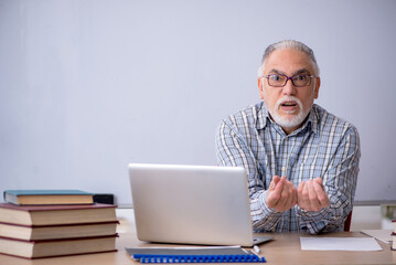 Old male teacher in the classroom