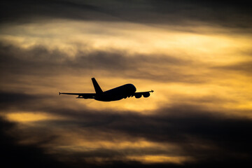 Passanger plane flying. Airliner in the sky. Aircraft take off in sunset.