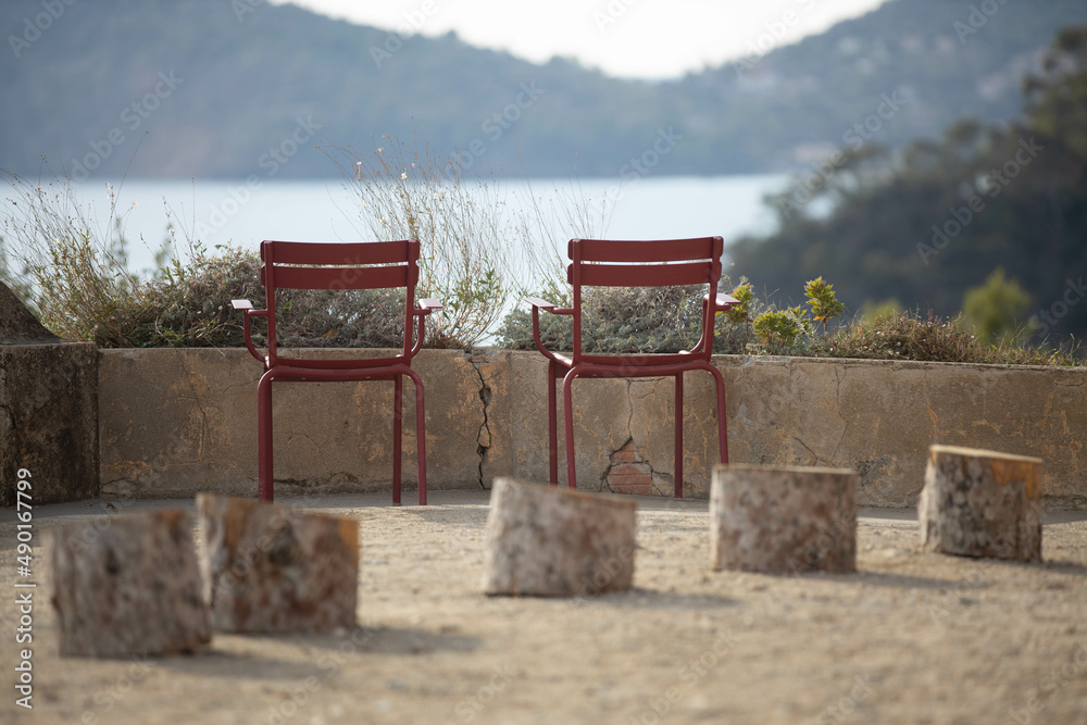 Canvas Prints Red empty metal chairs with a blurry view of a lake in the background