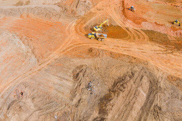 Aerial top view at excavator loads earth into a large dump truck