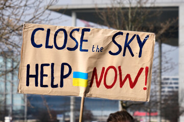 Closeup on packard with English text Close sky help now and Ukrainian flag. Protest against war in Ukraine in Berlin, Germany
