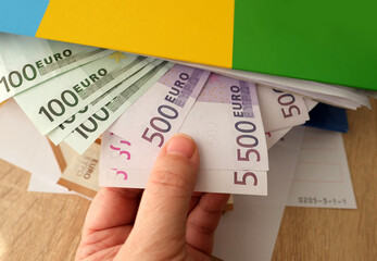 office folders close-up, 100, 50, 500 euro banknotes, concept of filling out tax return, paying...