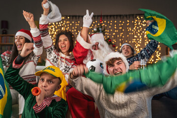 group of fans watching a sporting event sitting on the sofa in their living room