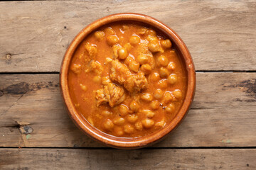 Closeup shot of tripe with chickpeas in a clay pot on a wooden table