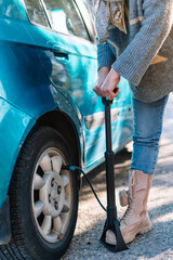 detail of a woman inflating a car tyre