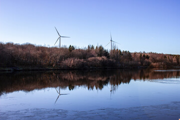 Daylight shot of a pond on the background of windmills - Powered by Adobe