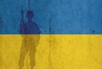 Keuken spatwand met foto Ukraine flag on wall and shadow of soldier. Ukraine war concept © raquel