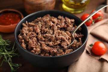 Fried minced meat and different products on wooden table, closeup