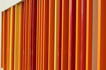 Orange, yellow and red vertical metal lines seen from the side