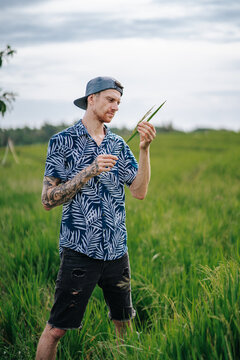 Vertical shot of a White man check the oat field Bali