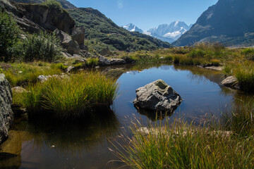 Schöne Aussicht auf den See zwischen den felsigen Bergen an einem sonnigen Tag © Bertrand Louis/Wirestock