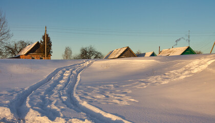 Beautiful shot of some country houses on a field covered in snow.