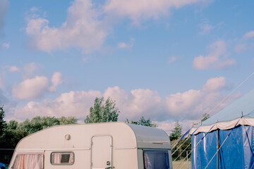 Beautiful shot of a cloudy blue sky over a circus caravan with a tent
