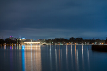 Maschsee at night in the moonlight with a blue sky and colorful reflections on the water