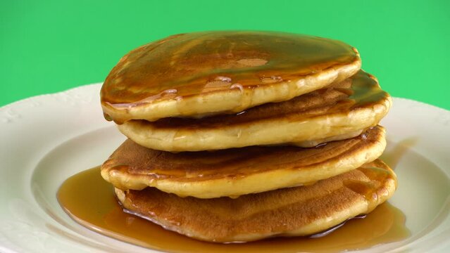 American pancakes with maple syrup on a green background.