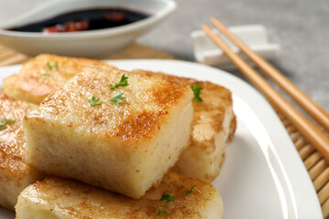 Plate with delicious turnip cake on table, closeup