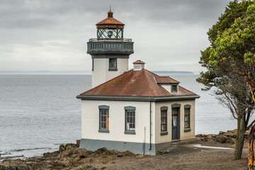 Lime Kiln Lighthouse surrounded by the water under a stormy sky in Washington State
