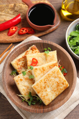 Delicious turnip cake with microgreens on wooden table, flat lay
