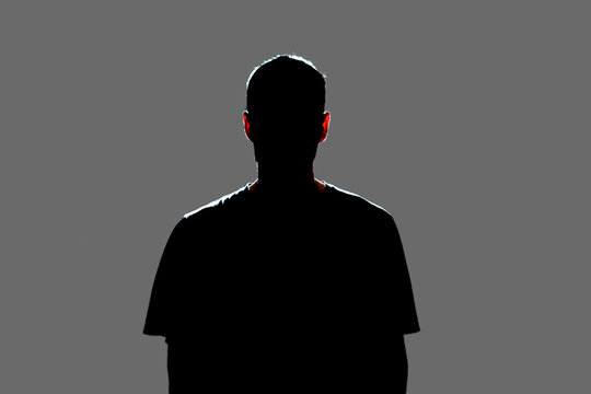 isolated dark male silhouette in the shadow, studio portrait