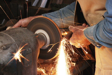 Closeup of an old man grinding metal with flame and fire, Local home repair old sewage