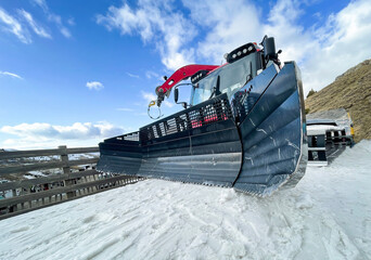 wide angle view of the blades of a snowcat on the snow, ski resort equipment, snowplow machine,...