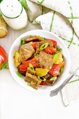 Meat with oranges in bowl on light board top