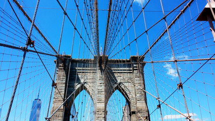 Low angle shot of the Brooklyn bridge under the blue sky