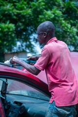 African Auto Bodyworks,  Welding a Car in Africa,  2 African men working on a car, African American auto mechanic at work, African American working with electrodes