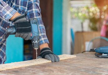 Carpenter use cordless screwdriver to driving screw nail.