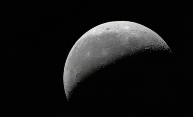 Half full gray moon in a dark black sky