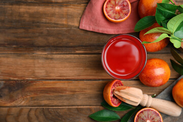 Tasty sicilian orange juice, fruits and squeezer on wooden table, flat lay. Space for text