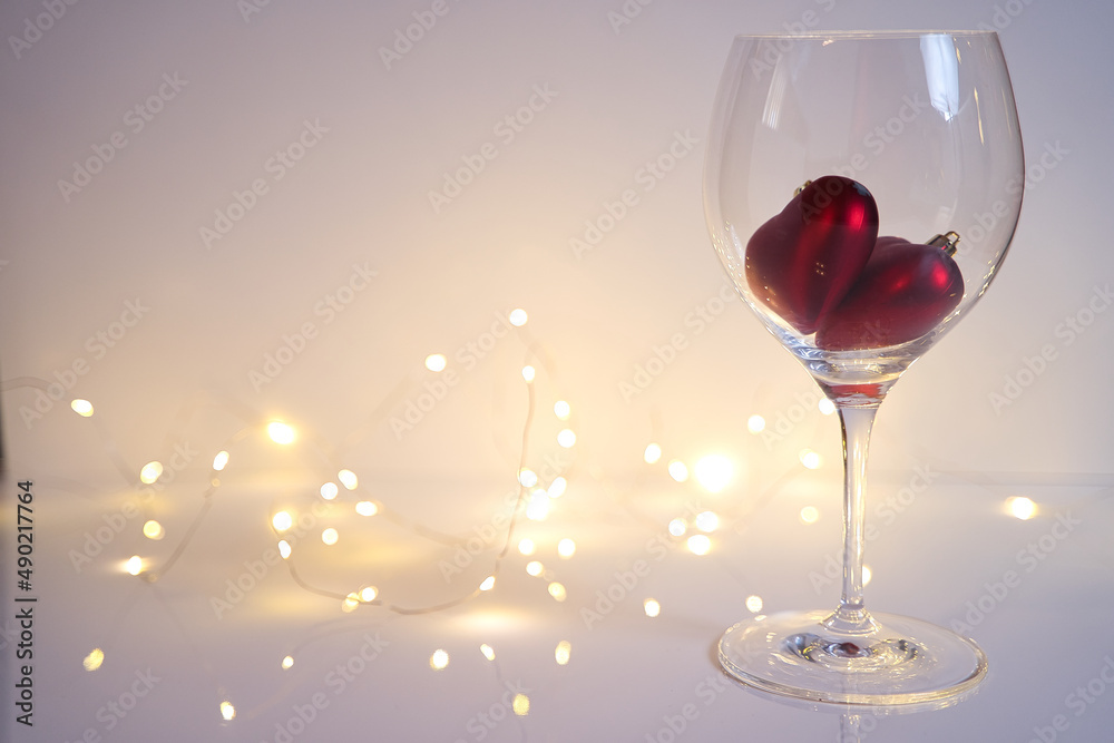 Wall mural Wine glass with two hearts against bokeh light - Valentines Day concept