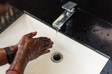 Closeup washing black man hands rubbing with soap and water in sinks to prevent outbreak coronavirus hygiene to stop spreading virus, hygiene for quarantine cleaning COVID-19 concept