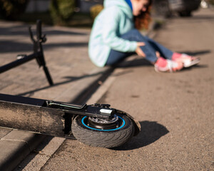 A Caucasian woman fell from an electric scooter and injured her leg. Suffering from pain. © Михаил Решетников