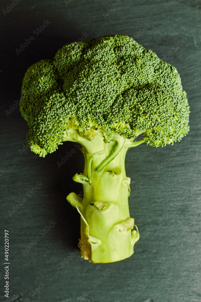 Sticker top view of a ripe broccoli on a dark green wooden table