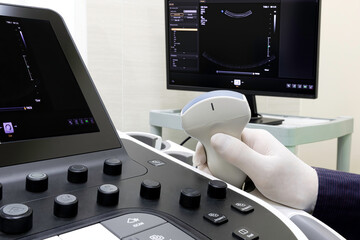 A doctor holding an ultrasound probe by the sonography machine. Professional modern medical...