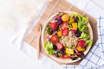 Fresh mixed fruits and vegetables salad in natural plate on white background, Healthy vegan food, Top view