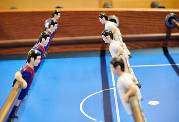 Soft focus of men figures on the rods of a foosball table