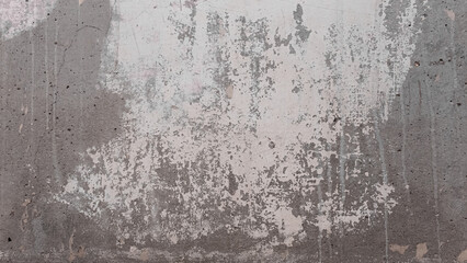 Old shabby white wall.Remains of plaster dried on the wall.Photo of a wall in a state of repair for the background.Stripped wallpaper from the wall.Stucco on gray concrete background.