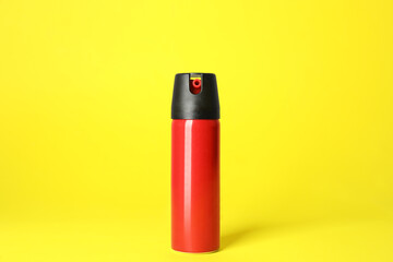 Bottle of gas pepper spray on yellow background