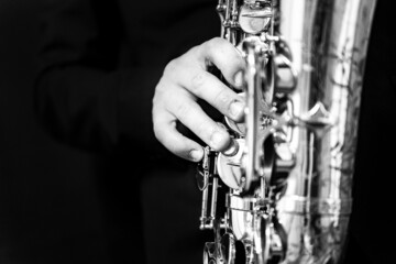 Grayscale of a man's hand playing a saxophone