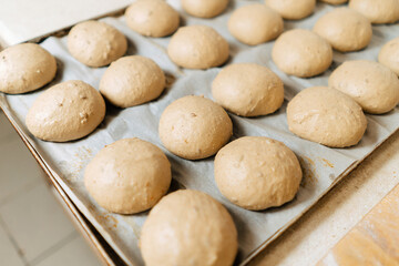 Dough blanks for homemade buns, laid out on a baking sheet. Pastries for the restaurant, homemade pastries.