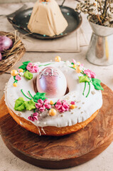 Obraz na płótnie Canvas Traditionl Easter kulich cake on wooden board over rustic stone background.