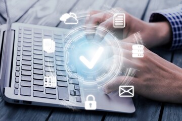 Businessman holding laptop with virtual document and mark correct sign