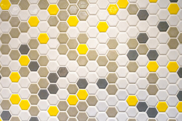 Small mosaic tile wall in gray, yellow and white colors