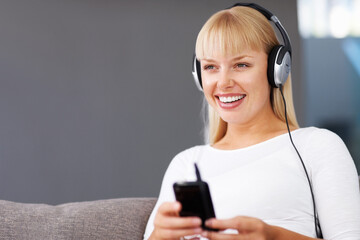 Music lover. Closeup of smiling young woman listening music through MP3 player.